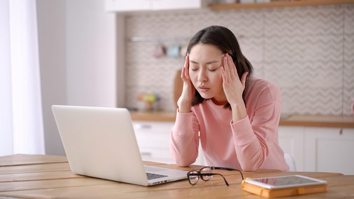 Signs you need new glasses - woman working from home take off glasses feel eye strain fatigued from laptop computer
