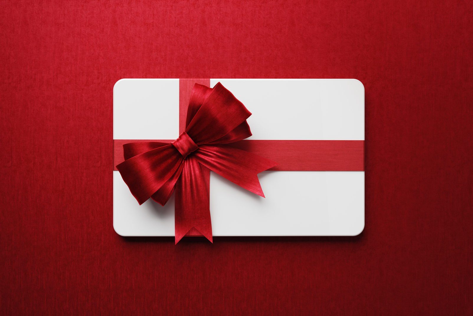 White Gift Card With Red Bow Tie On Red Background