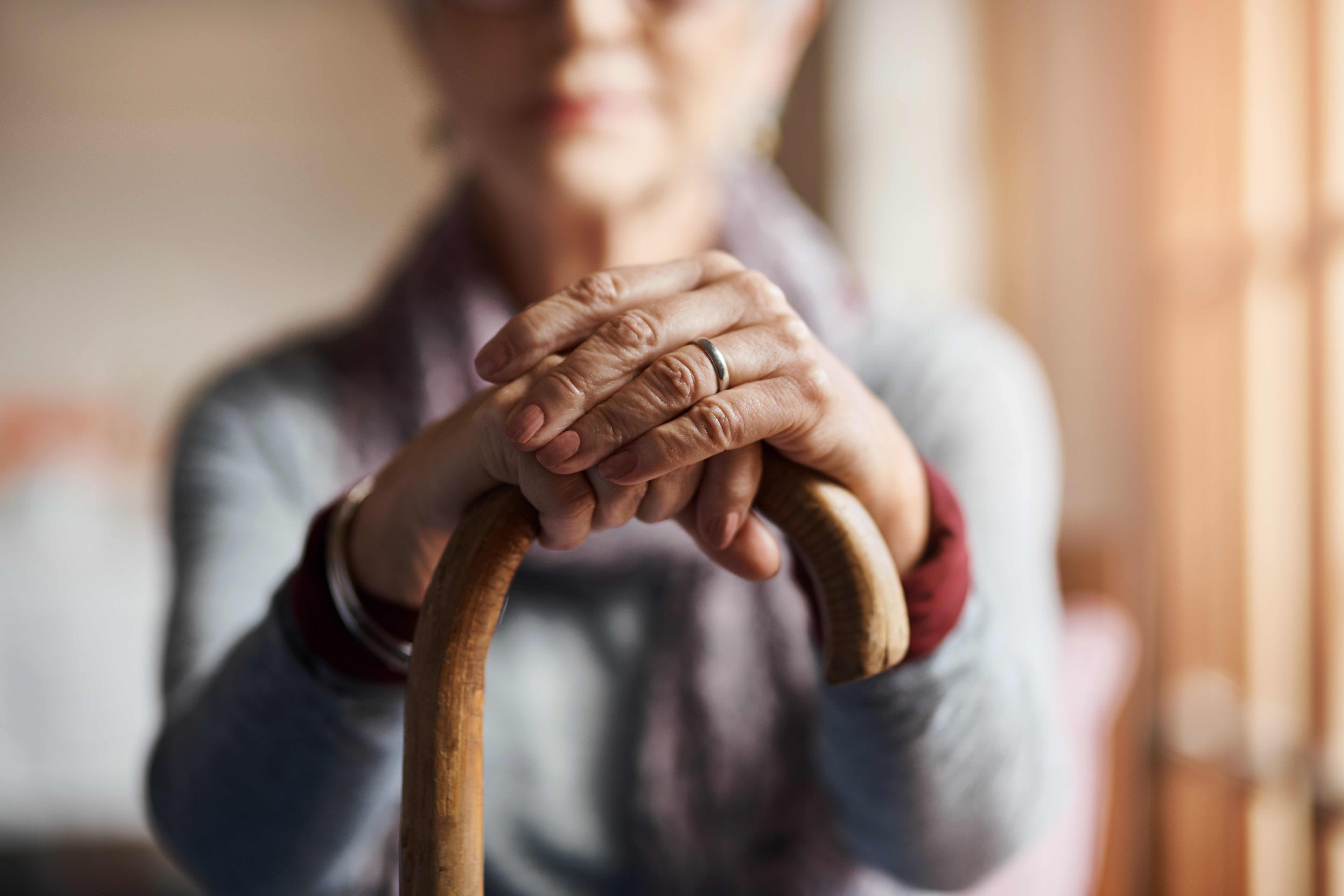 senior woman holding a cane in a retirement home elderly