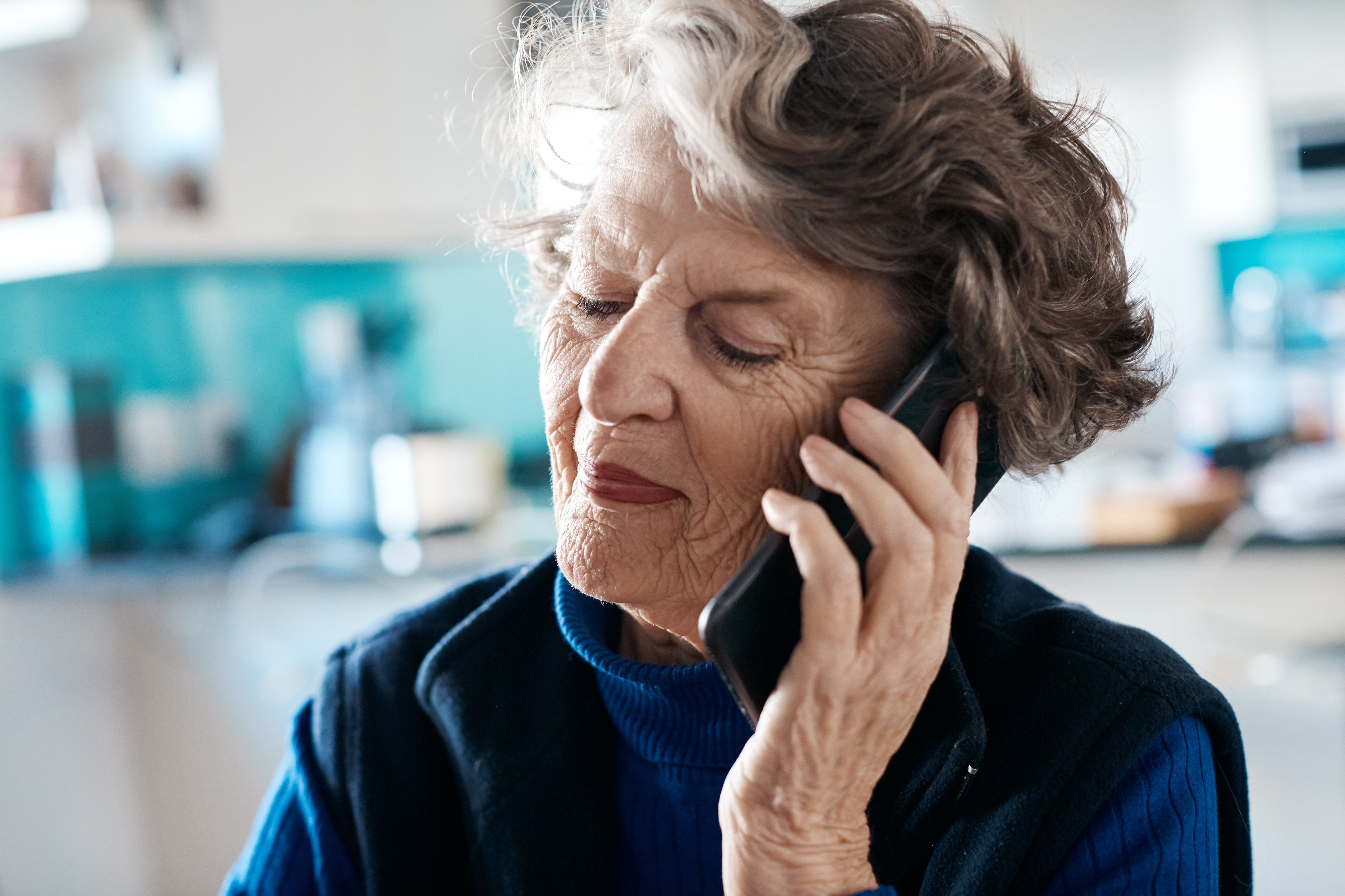 Smiling senior woman talking on mobile phone at home