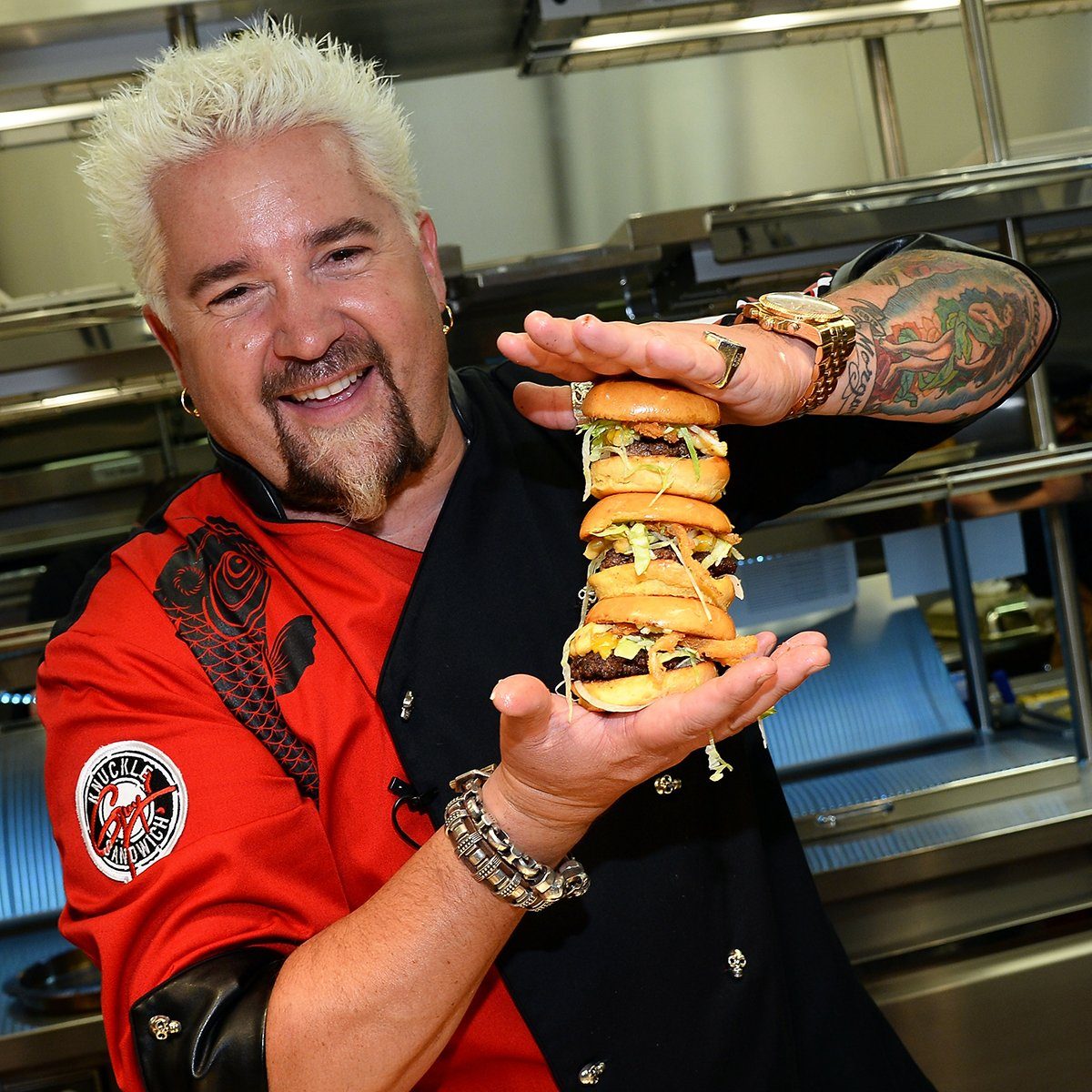 LAS VEGAS, NV - APRIL 04: Chef and television personality Guy Fieri holds hamburgers in the kitchen during a welcome event for Guy Fieri's Vegas Kitchen & Bar at The Quad Resort & Casino on April 4, 2014 in Las Vegas, Nevada. The restaurant opens on April 17. (Photo by Ethan Miller/Getty Images for Caesars Entertainment)