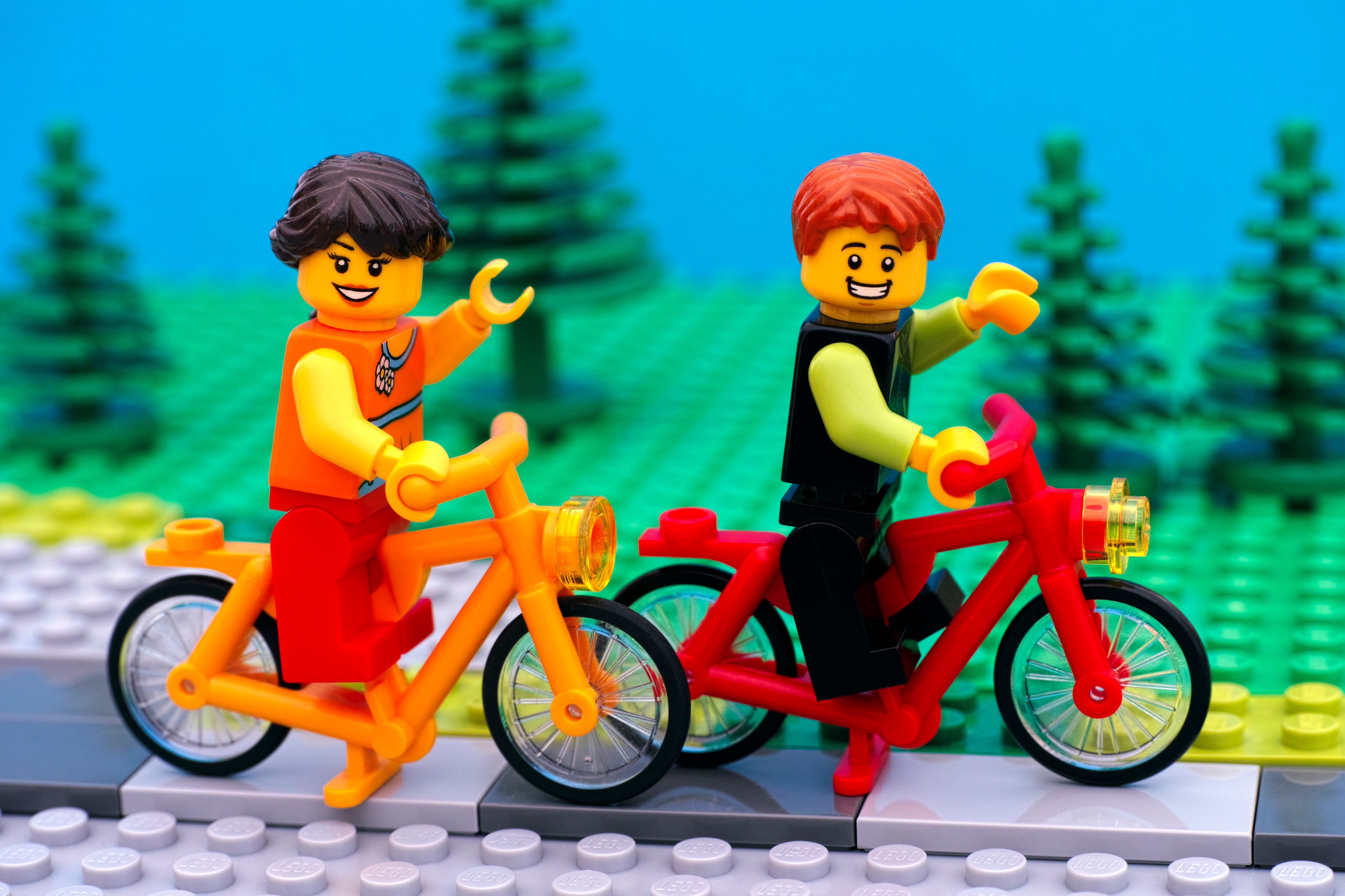 Lego boy and girl riding bikes in park