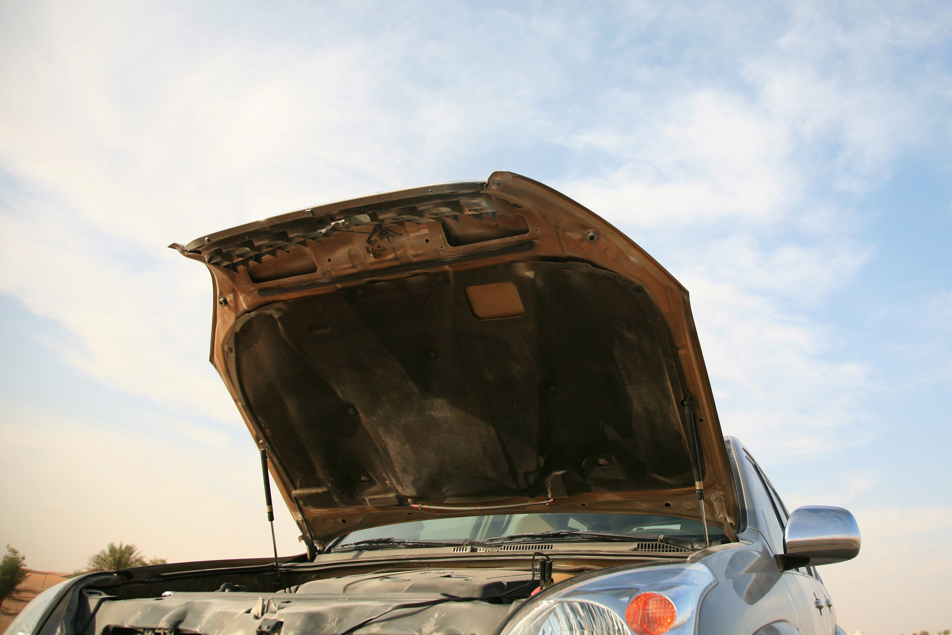 Lifted hood of a car showing damage inside