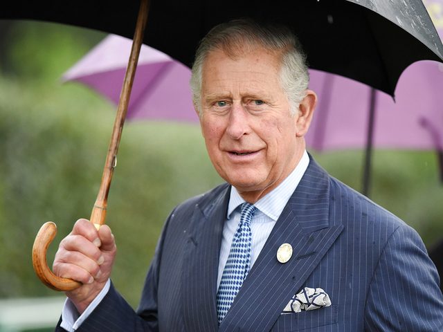 Prince Charles carrying an umbrella
