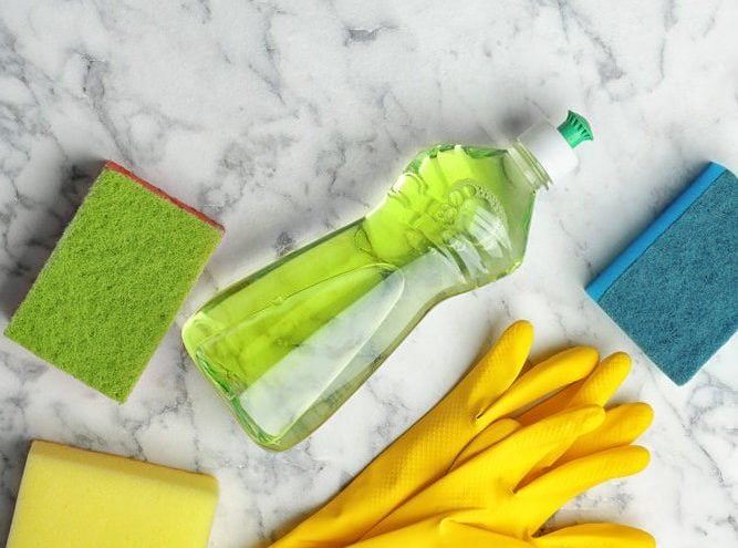 Flat lay composition with cleaning supplies for dish washing and space for text on marble background