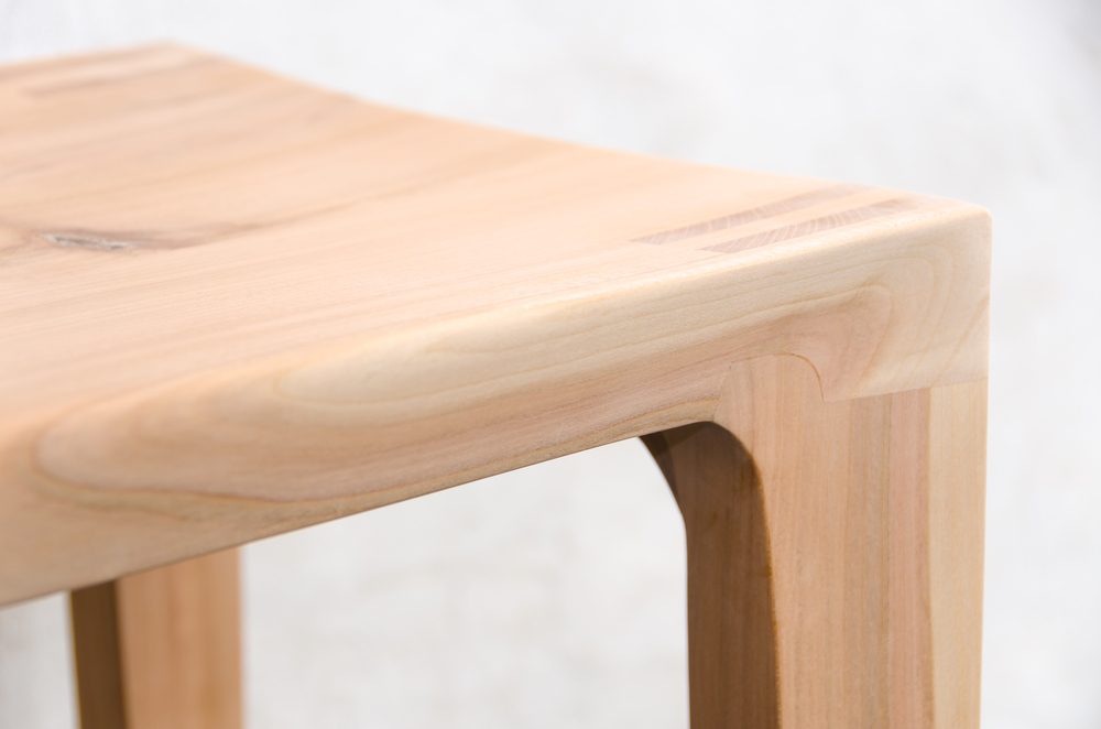 Detail of a wooden glued joint of a chairs leg. Material used for the stool is cherry wood untreated with a sanded finish