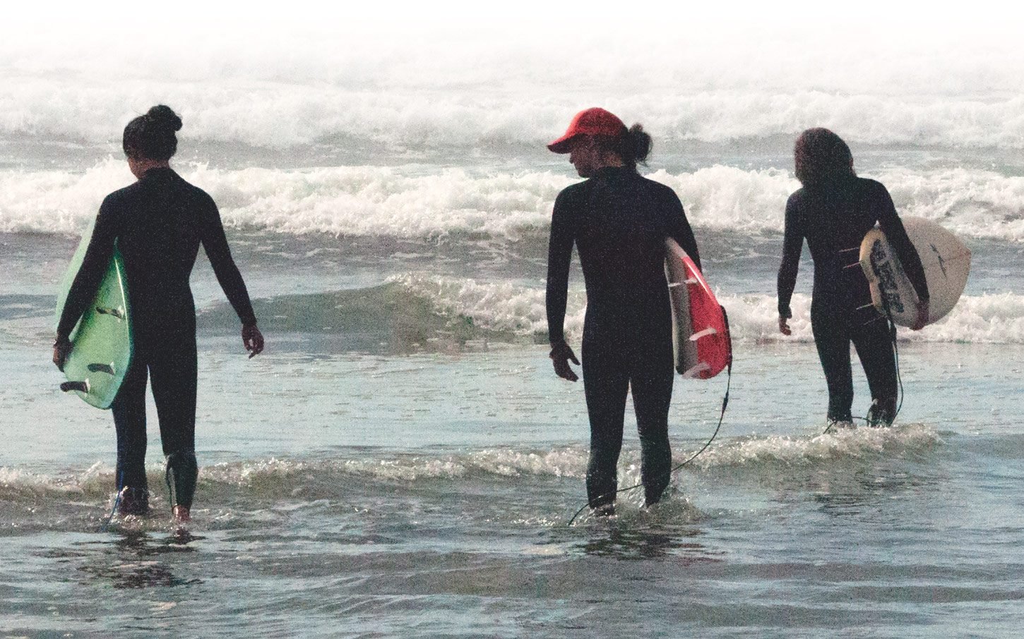 Surfers heading out with their boards in Tofino, British Columbia