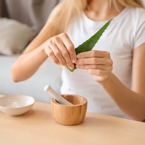 what is the secret to beautiful skin - Young woman making healthy facial mask with aloe vera extract at home