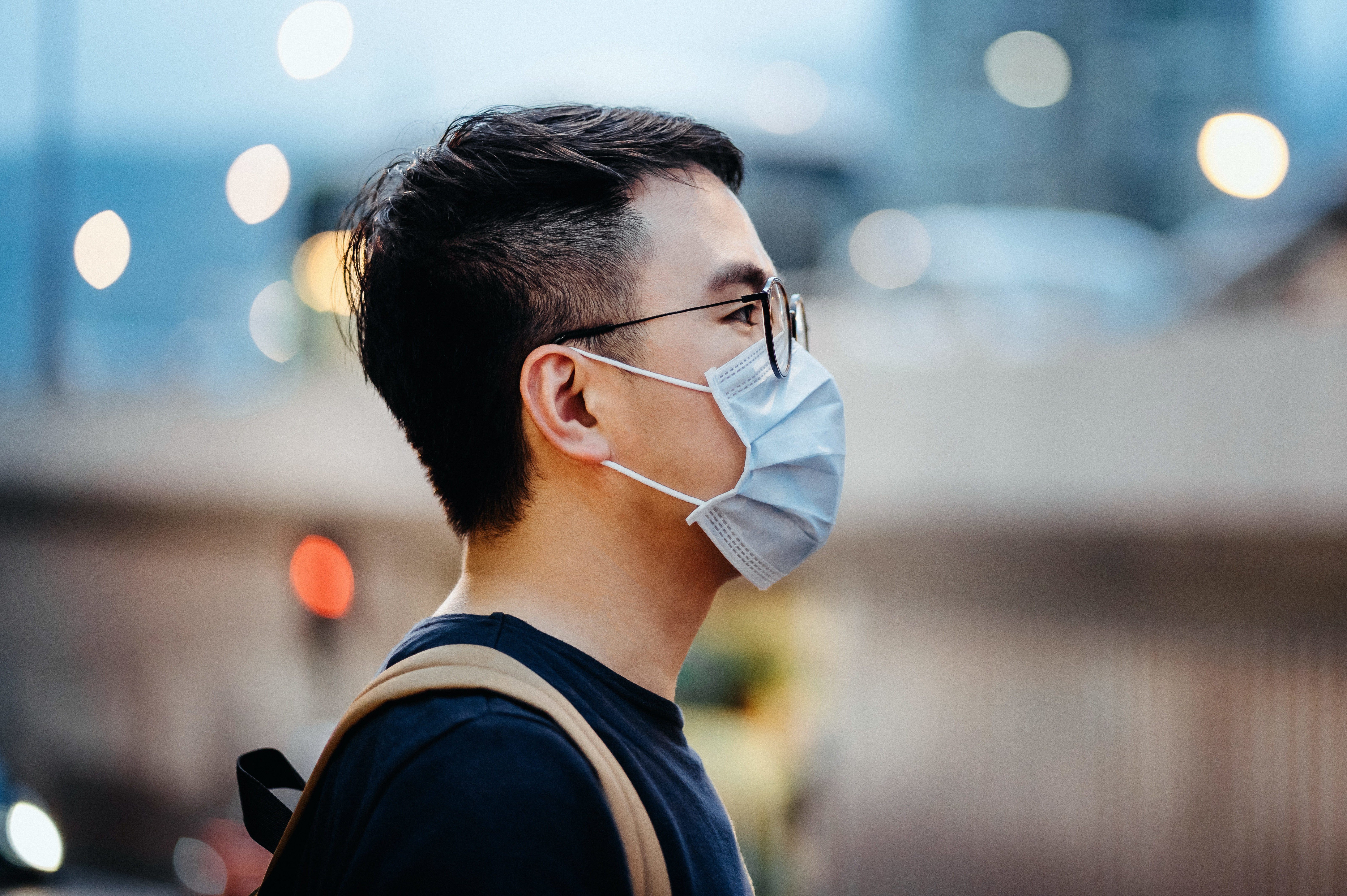 Portrait of young Asian man with face mask to protect and prevent from the spread of viruses in the city