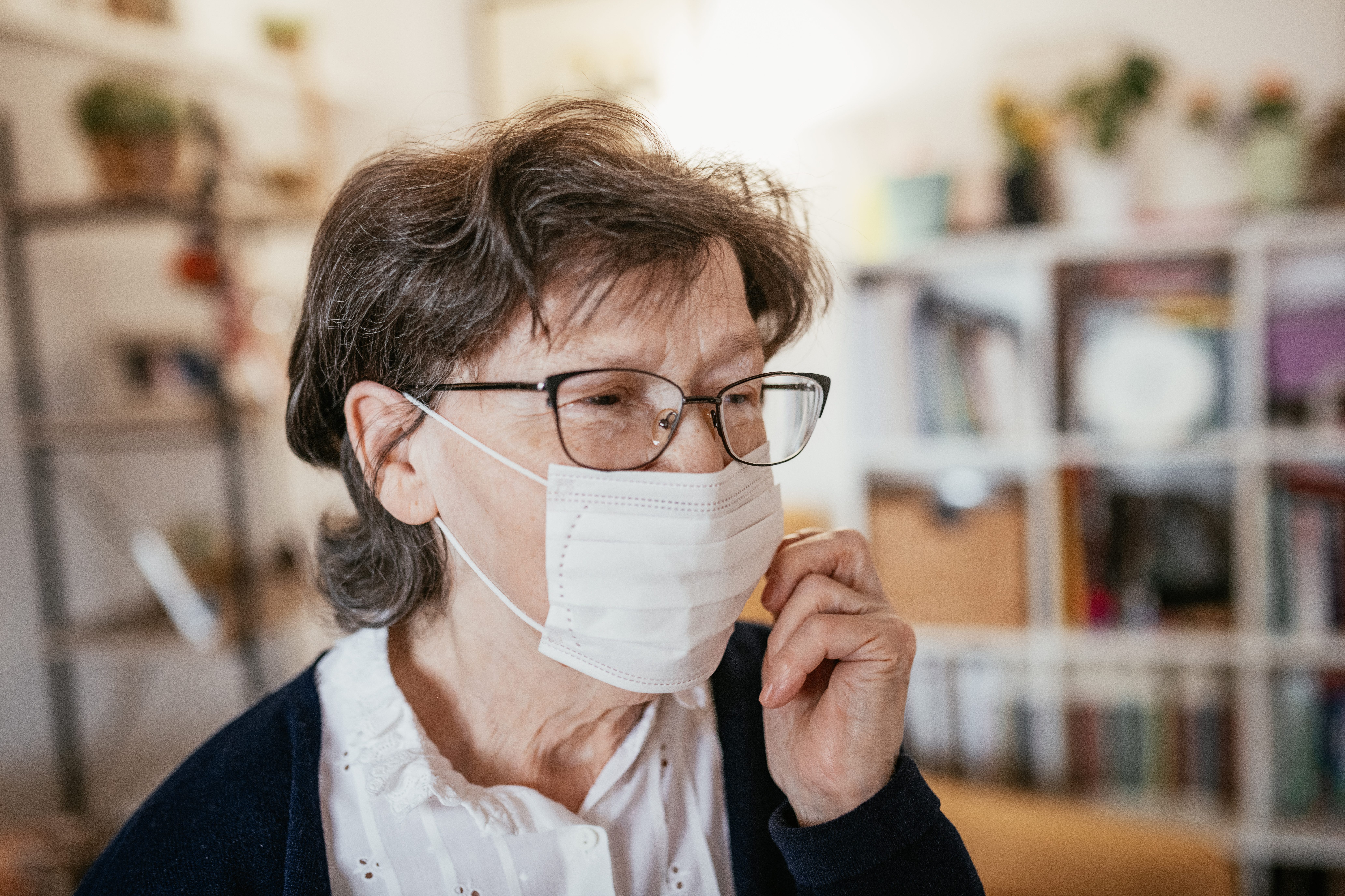 Senior woman with hygienic facial mask at home