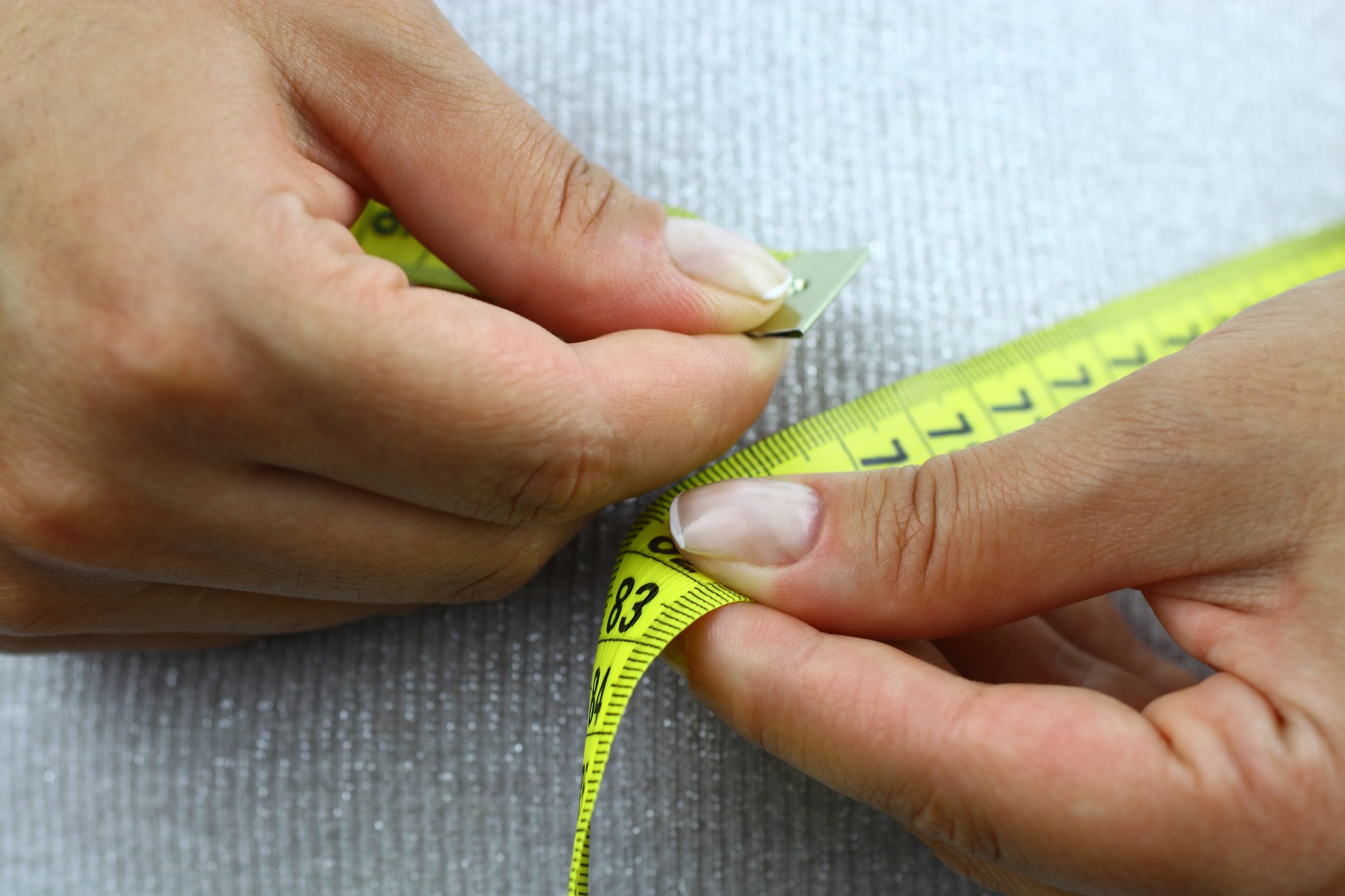Person measuring their waste line