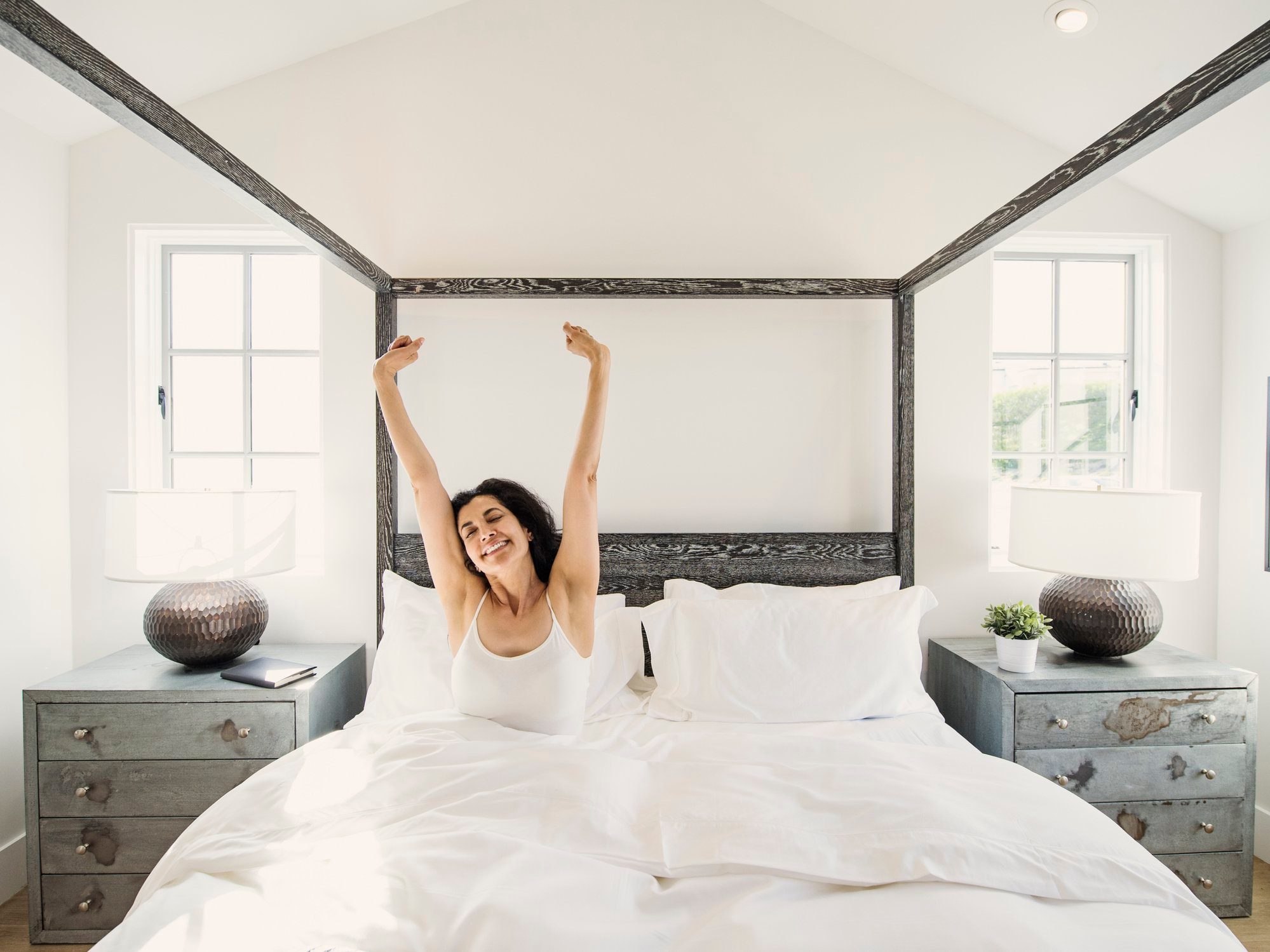 woman waking up happy in bed in the morning