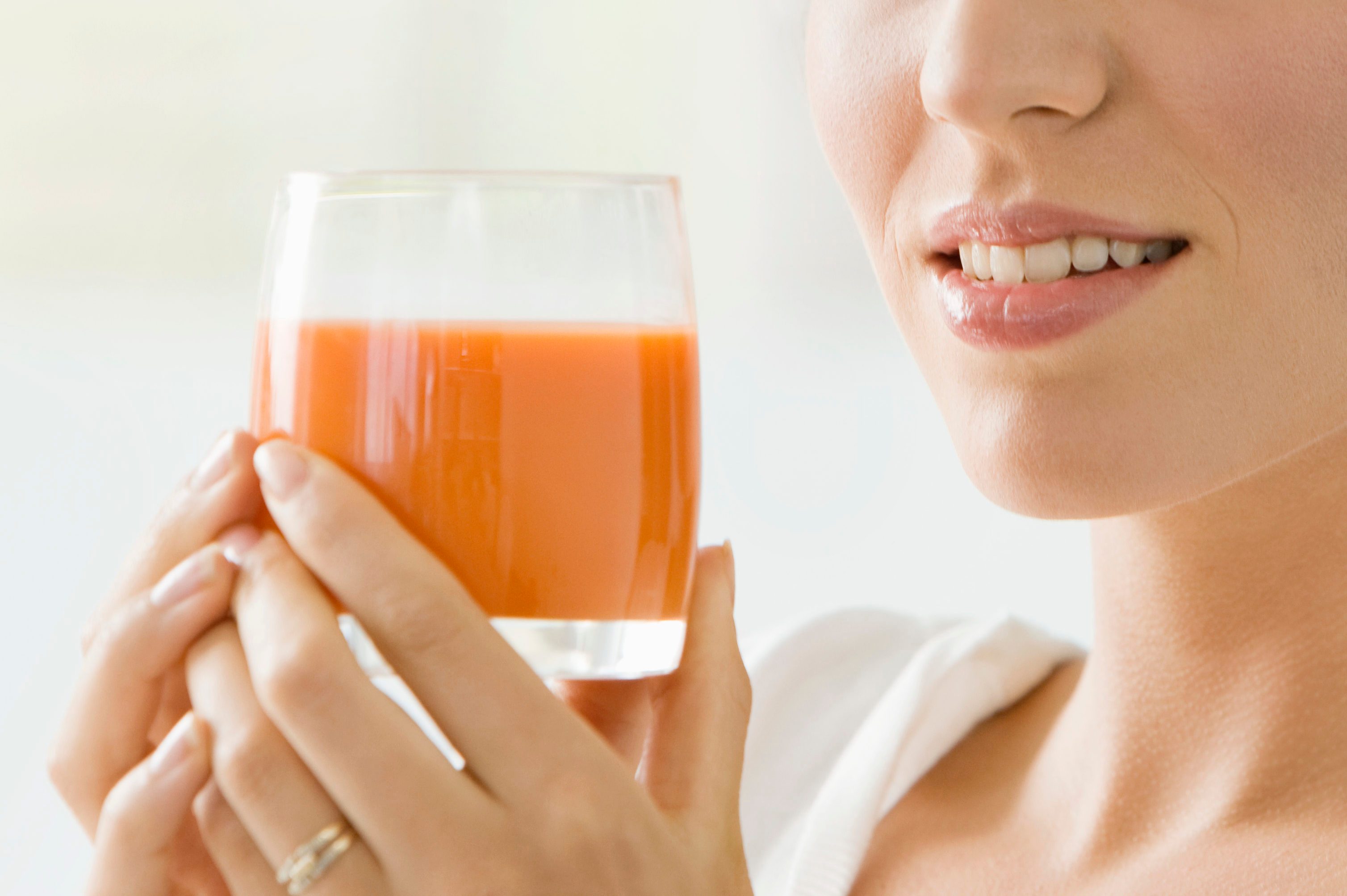 Woman holding a glass of tomato soup