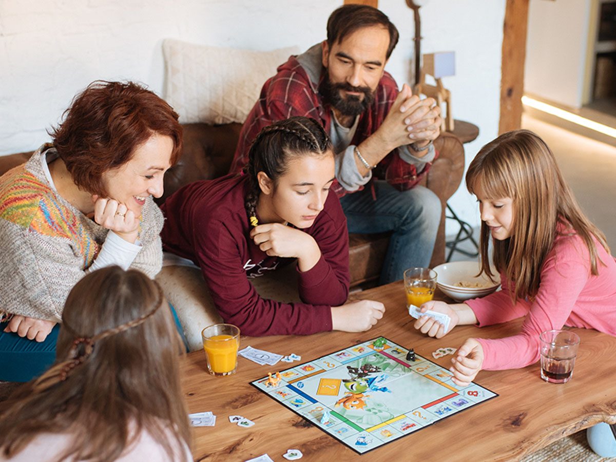 Family playing a game of monopoly.