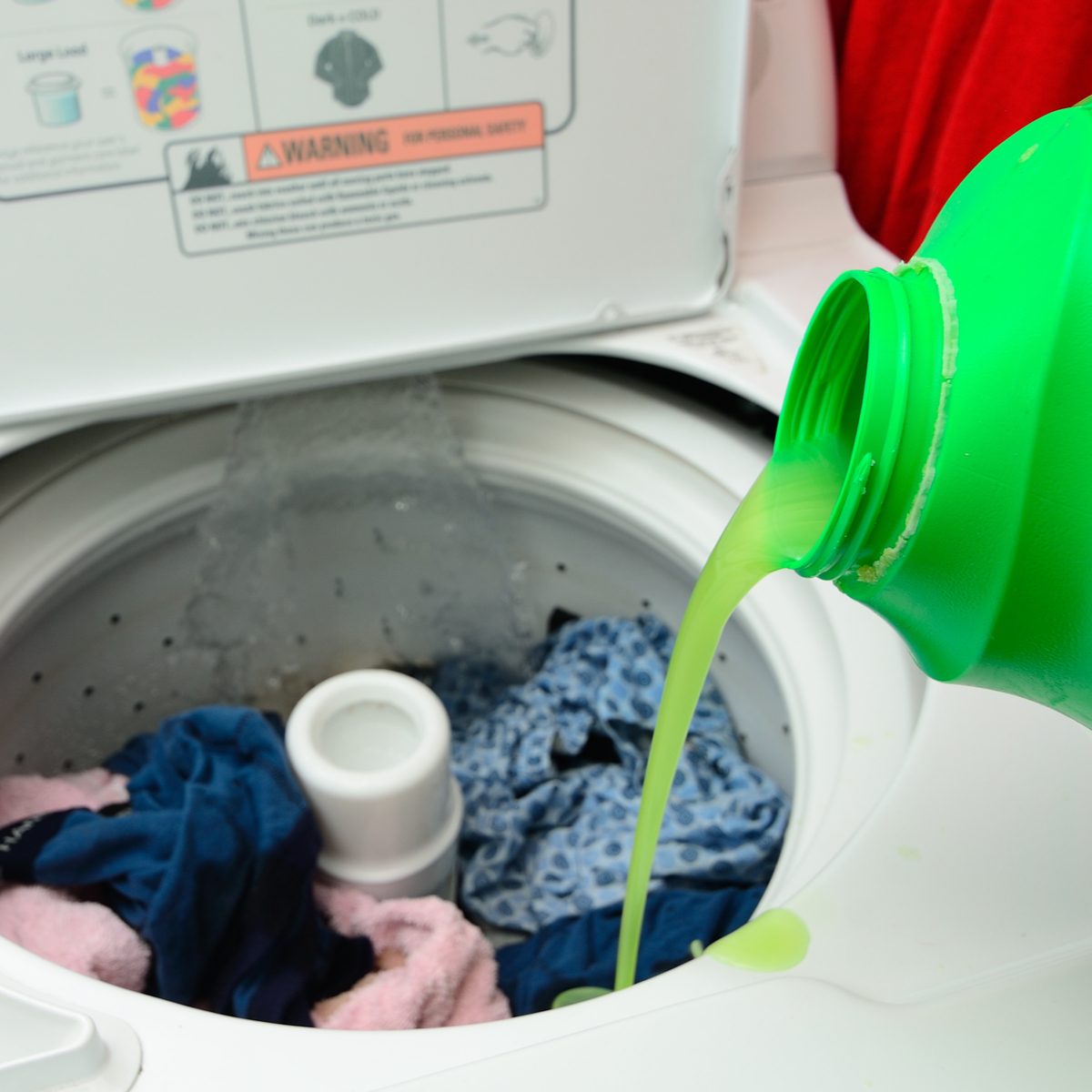 Pouring laundry detergent into washing machine