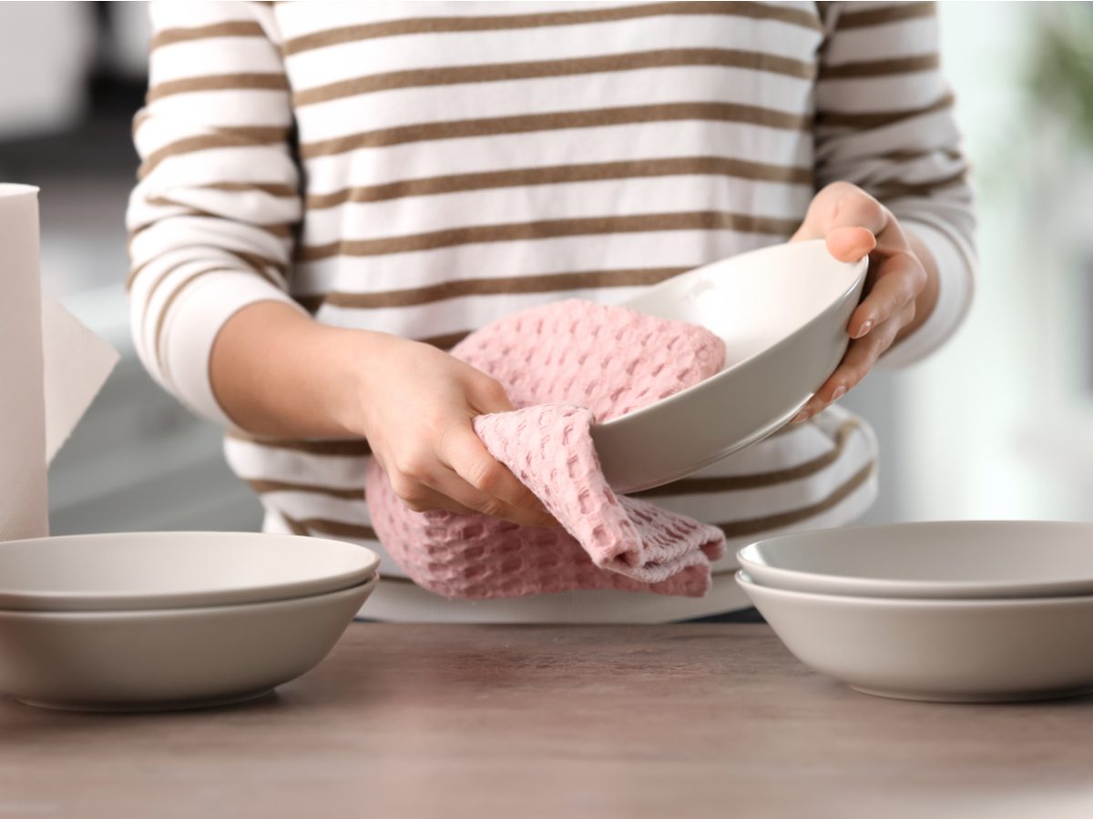 Woman drying bowl with dish towel