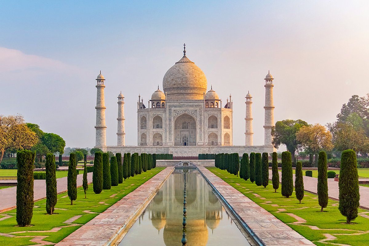 Taj Mahal front view reflected on the reflection pool, an ivory-white marble mausoleum on the south bank of the Yamuna river in Agra, Uttar Pradesh, India. One of the seven wonders of the world.