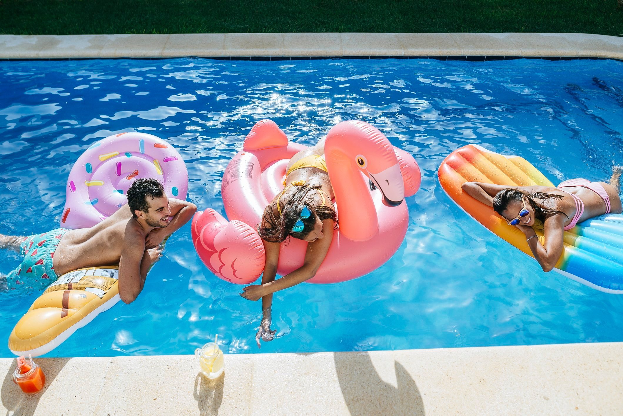 Happy friends on floats in swimming pool