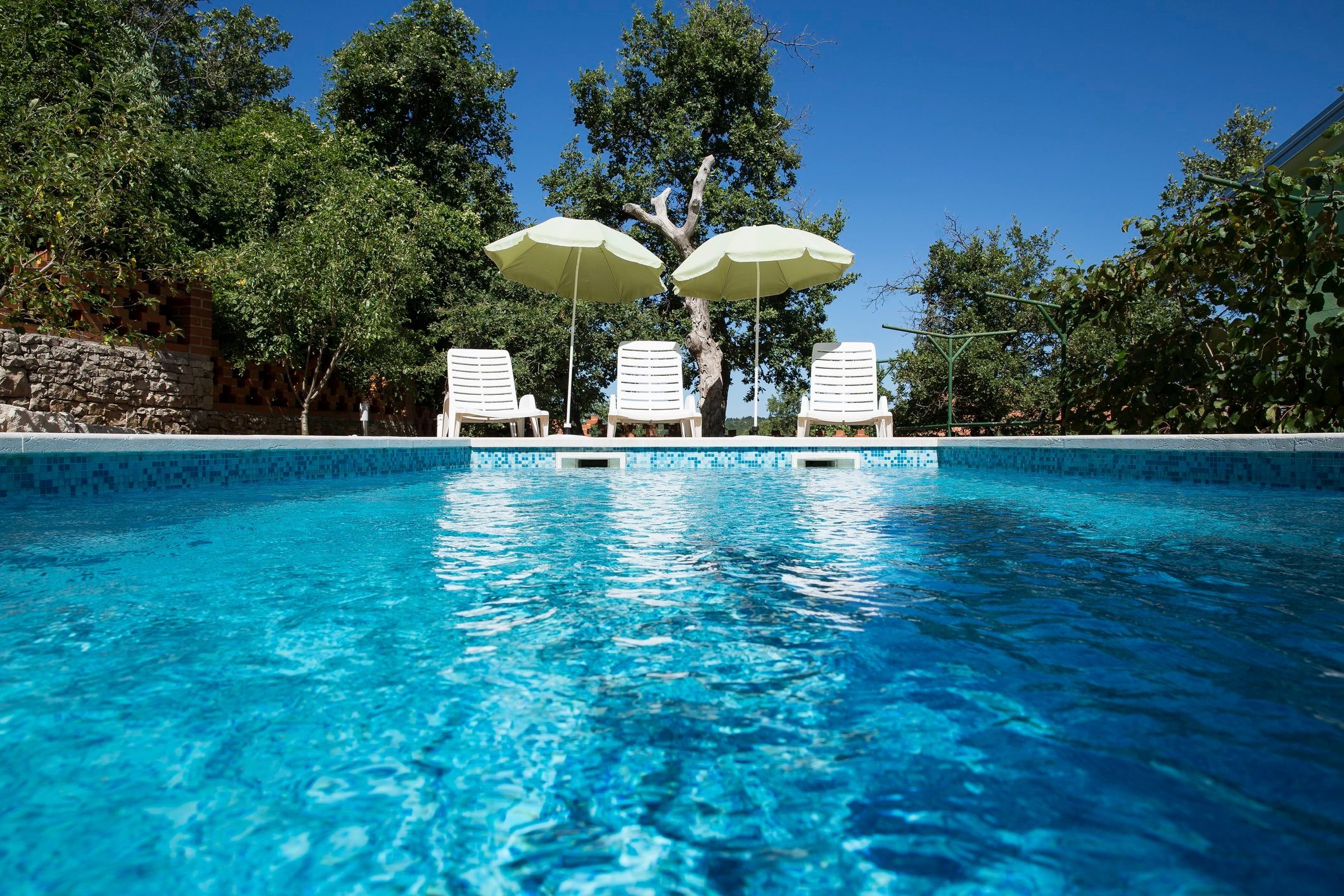 Croatia, Istria, three empty sun loungers at swimming pool