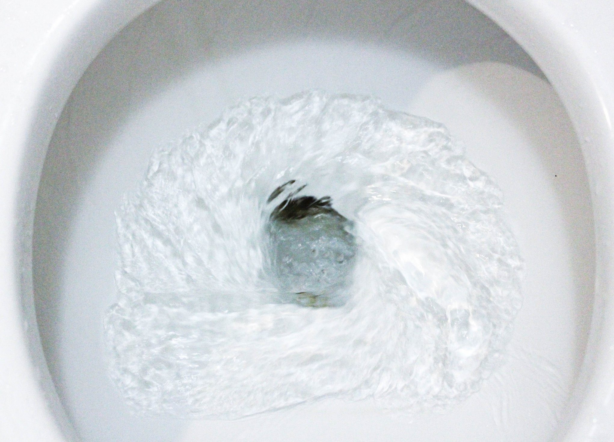 selective focus close up flushing toilet bowl for sanitary