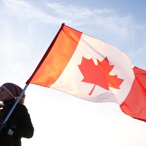 Canada National Anthem - Man on the top with Canadian flag. Winner and motivation concept.