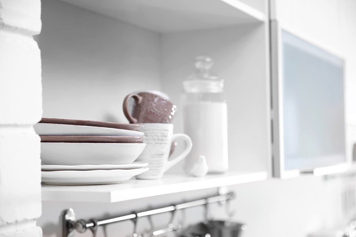 Cups and plates on a kitchen shelf.