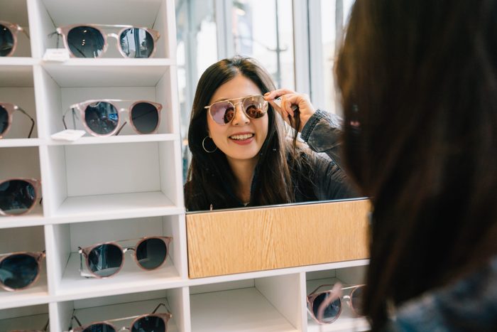 Sunglasses myths - Woman trying on glasses in store