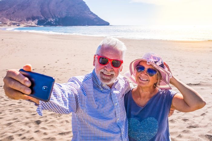 Sunglasses myths - Older couple taking selfie on beach
