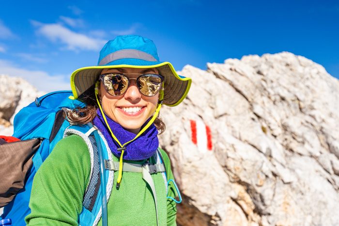 Sunglasses myths - Woman backpacker hiking with sunglasses