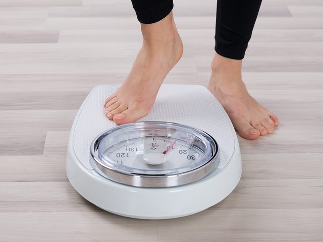 dental problems - woman weighing on scale