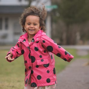 What I'm thankful for - Cute little girl smiling and laughing while running on a sidewalk
