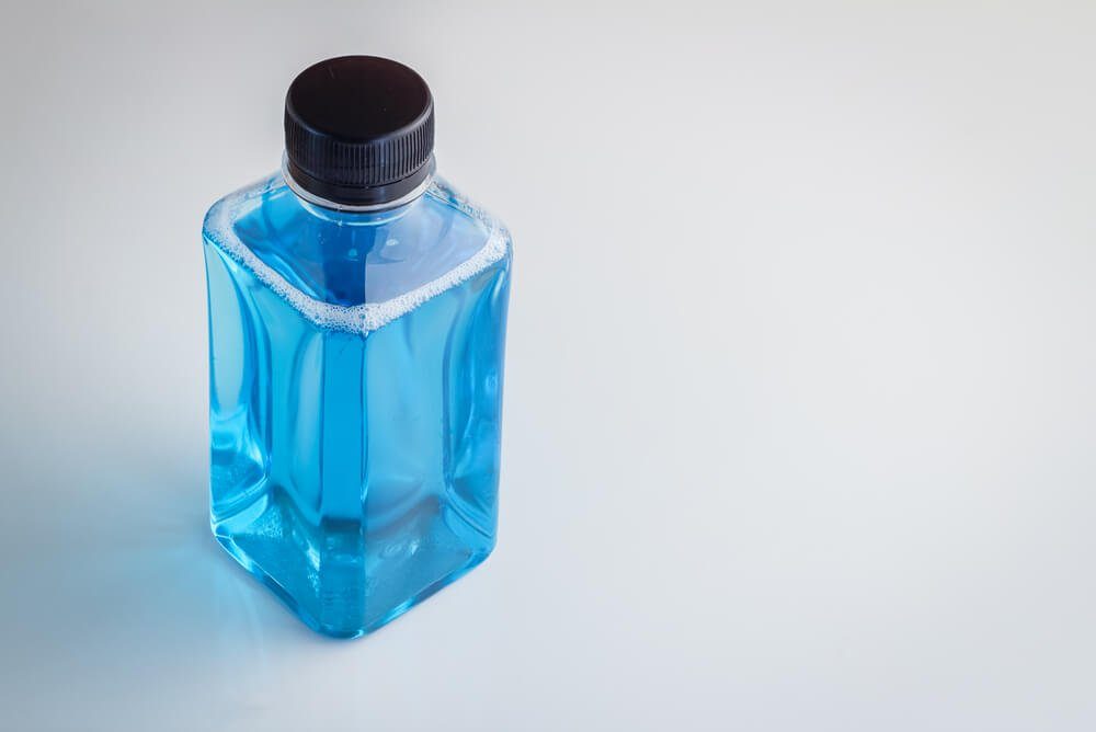 Plastic bottle of mouthwash on white background