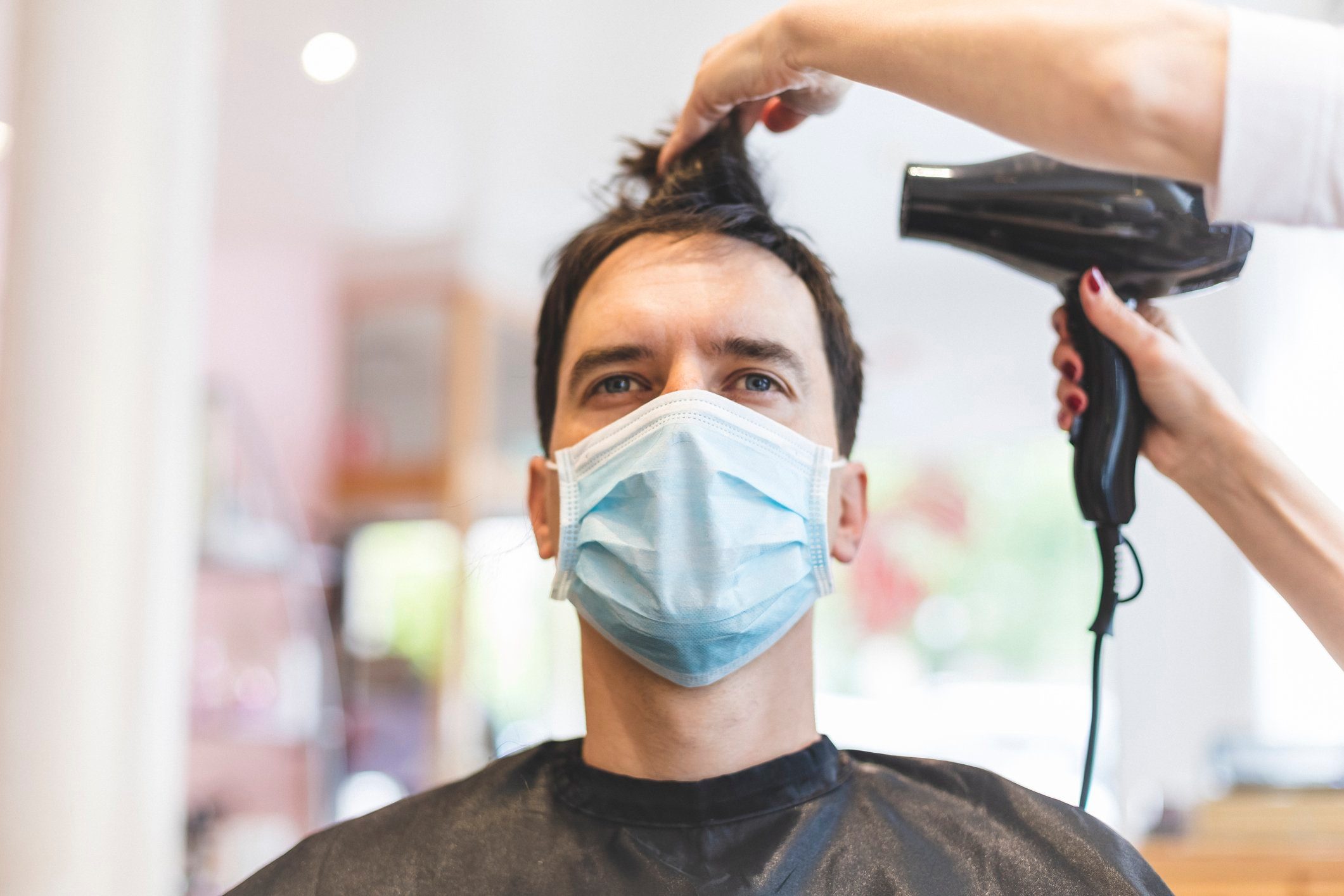 Hairdresser Drying Hair of Customer Wearing Protective Mask