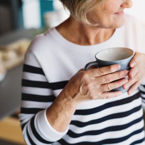unrecognizable senior woman holding cup of coffee