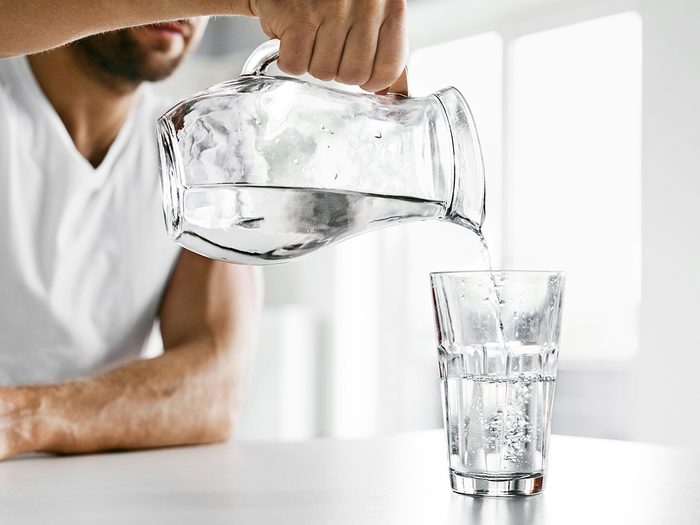 How much water you should drink - man pouring glass of water