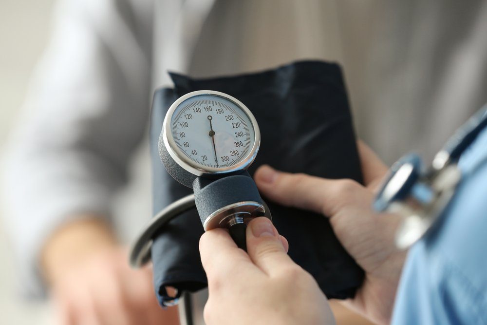 Medical assistant preparing to measure patient's blood pressure