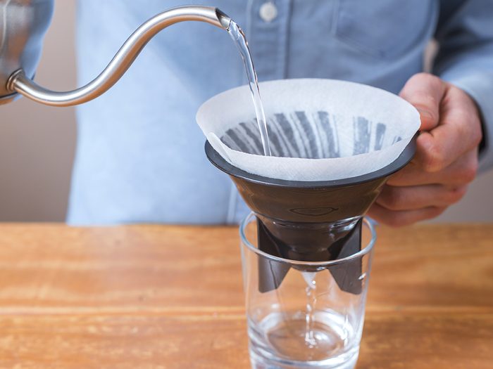 Uses for coffee filters - coffee brewing, step by step. Barista prepares cold brew. Wetting the paper filter.
