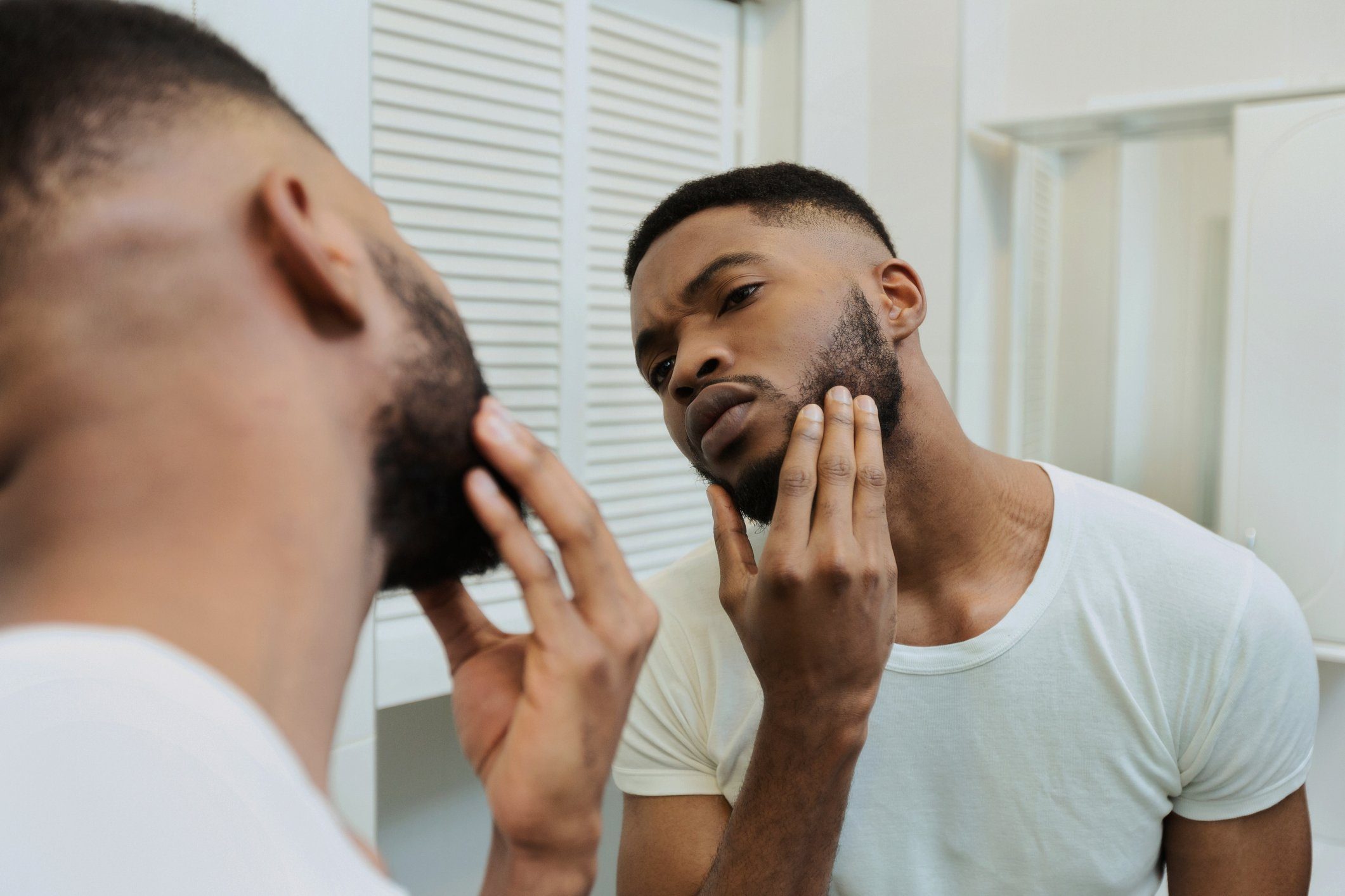 man inspecting beard in mirror