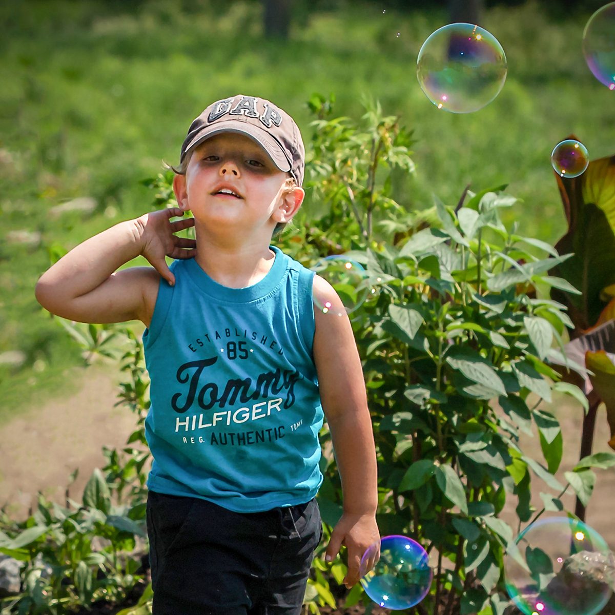 In the backyard photography - boy chasing bubbles