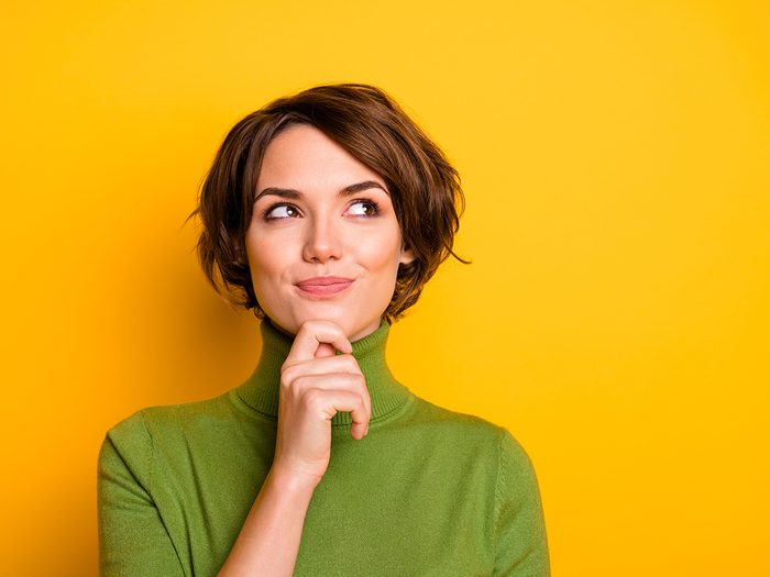 Smartest zodiac sign - Closeup photo of amazing short hairdo lady looking up empty space deep thinking creative person arm on chin wear casual green turtleneck isolated yellow color background