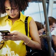 Text slang - Young woman using a smartphone in a subway