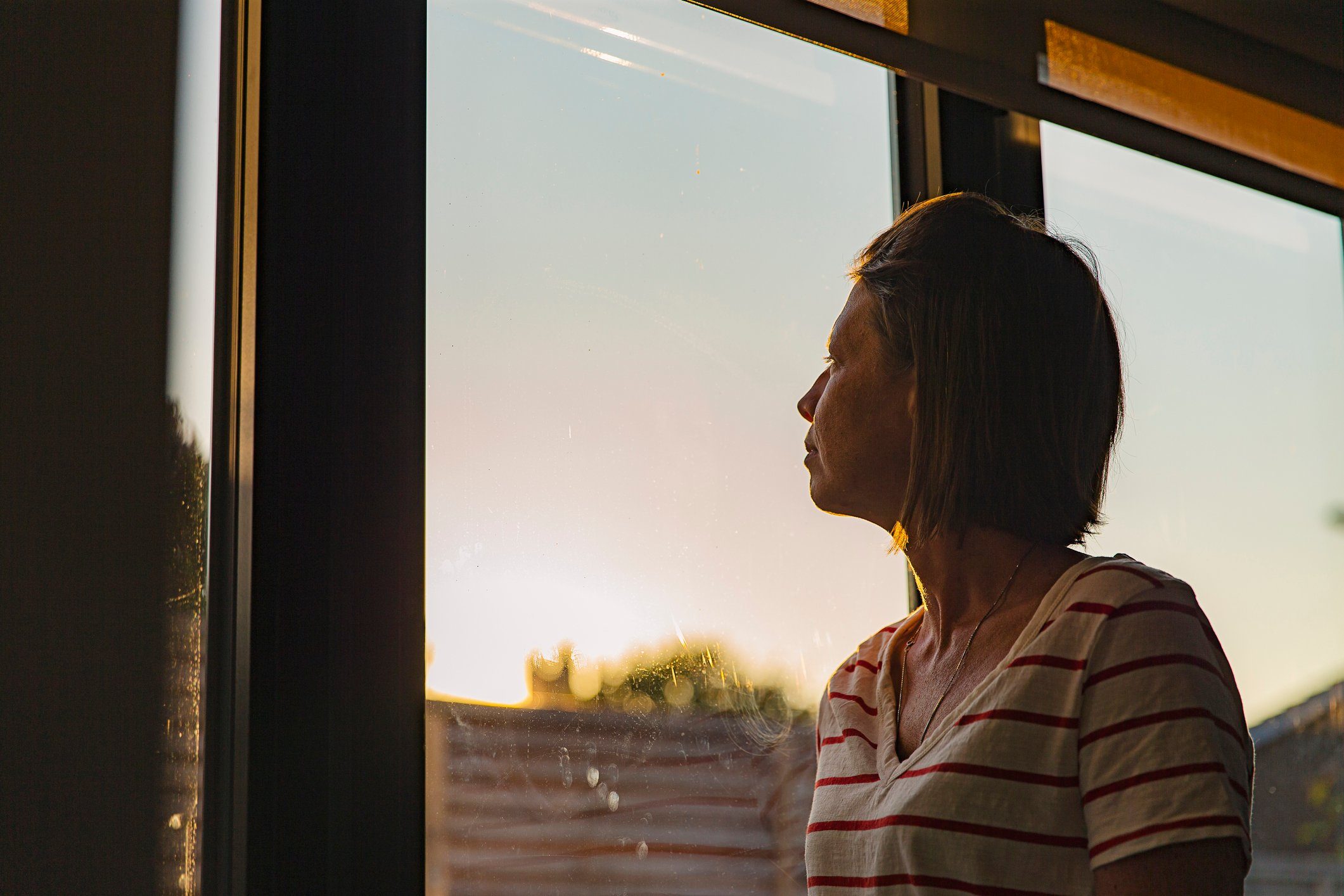 Woman looking through window - negative emotion