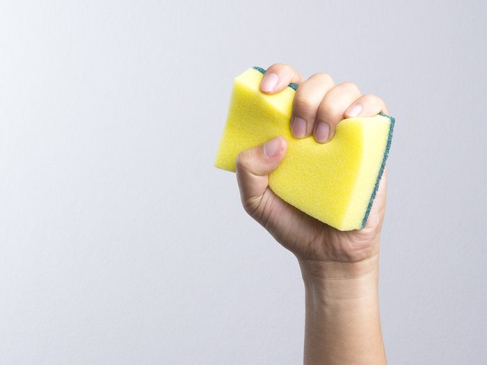 Kitchen sponge hacks - hand holding kitchen sponge