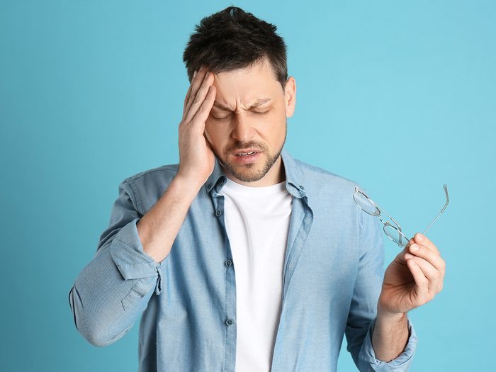 Symptoms of shingles - man with light sensitivity migraine