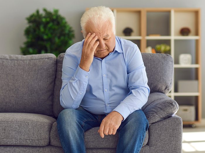 Symptoms of shingles - senior man with a headache
