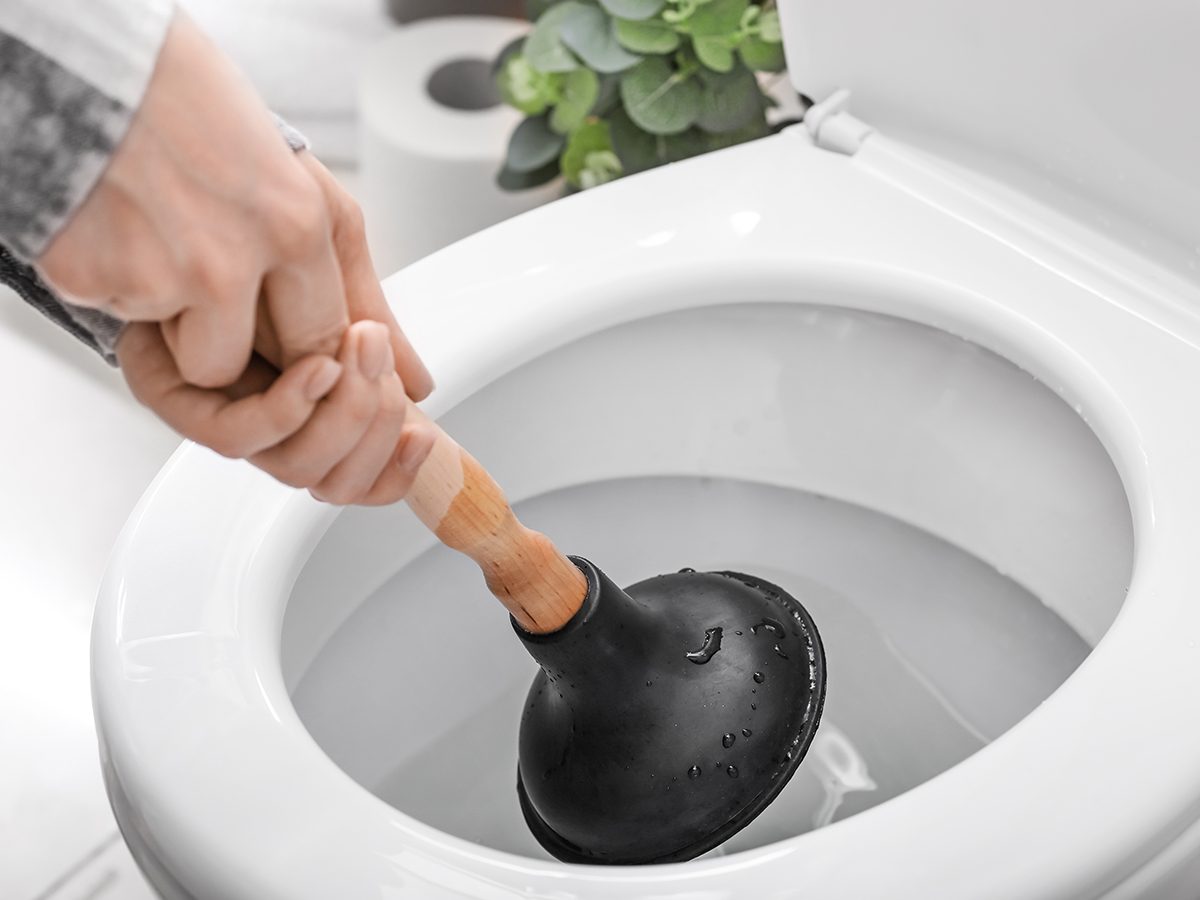 Bad cleaning habits - person using plunger on toilet