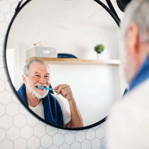 Bathroom mistakes - A senior man brushing teeth in bathroom indoors at home. Copy space.