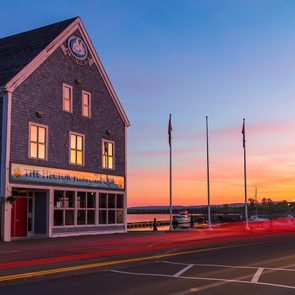 Day trips from Halifax - Hector Heritage Quay museum and flagpoles in sunset light with car tail light trails in the foreground.