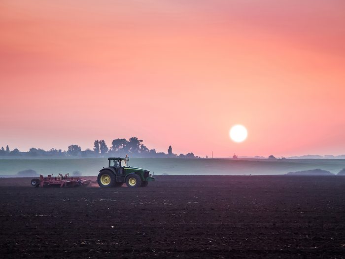 Daylight saving time myths - tractor in field at sunrise