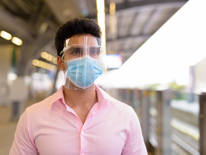 Do face shields really stop coronavirus - man wearing mask and face shield at train station
